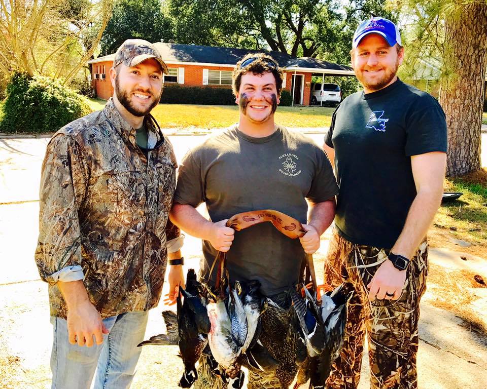 Three hunters with a Red River Leather game carrier after a duck hunt.