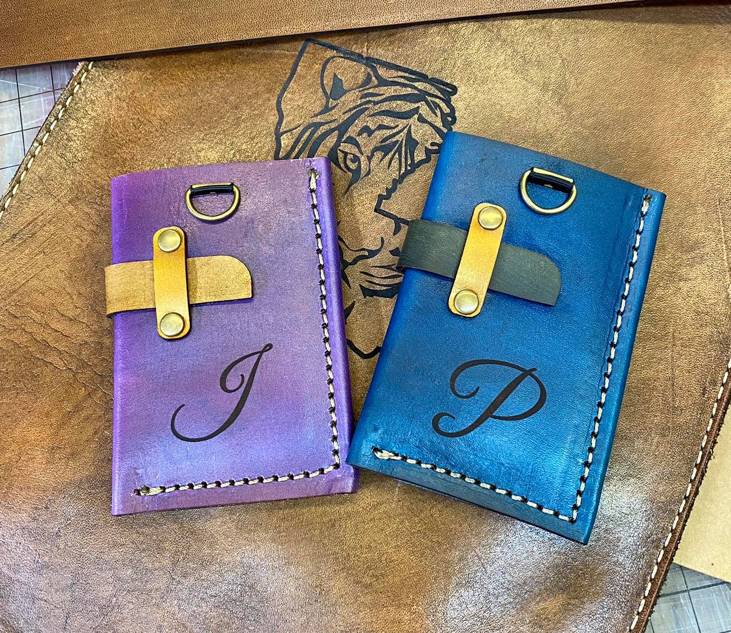 Two monogrammed leather notebooks resting on a full-grain leather hide.